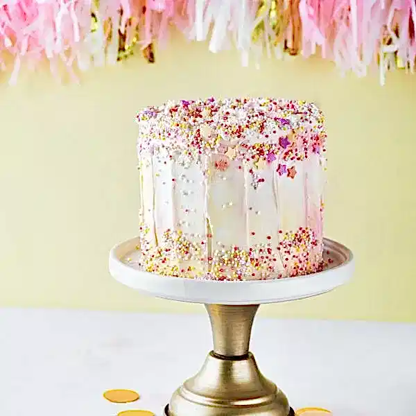 colorful-birthday-cake-with-sprinkles-on-a-yellow-background-.jpg